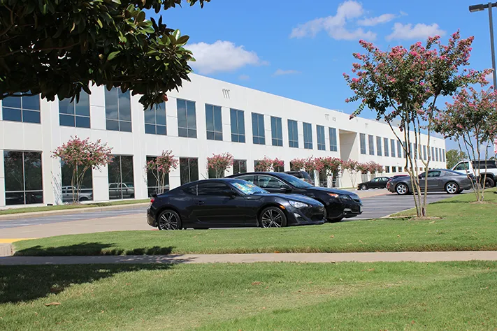 The 4025 Midway Road building in Carrollton, Texas, with landscaped grounds and surface parking