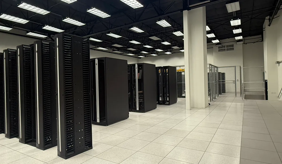 Rows of black server cabinets and secure cages on a raised floor in the McKinney data center